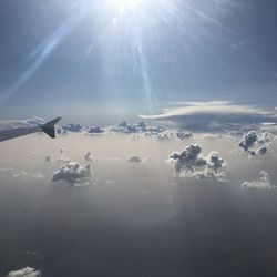 Low angle view of sunlight streaming through clouds