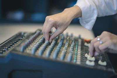 Cropped hand of man using sound mixer