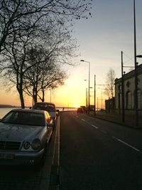 Cars on road against sky during sunset