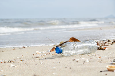 Close-up of water bottle at beach