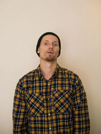 Portrait of a young man looking away against white background