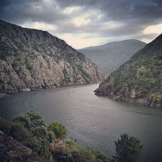 mountain, water, sky, mountain range, tranquil scene, tranquility, scenics, lake, beauty in nature, cloud - sky, nature, cloudy, river, cloud, reflection, non-urban scene, idyllic, landscape, tree, outdoors