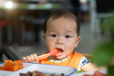 Close-up portrait of cute baby girl eating food