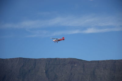 Low angle view of airplane flying against sky