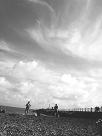 People in water against cloudy sky