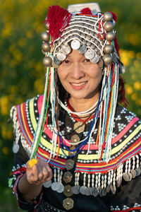 Portrait of smiling woman in traditional clothing standing at farm