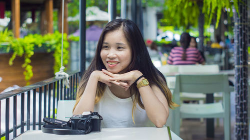 Portrait of a smiling young woman sitting outdoors