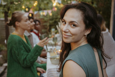 Portrait of smiling woman with friends celebrating in back yard