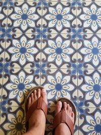 Low section of man standing on tiled floor