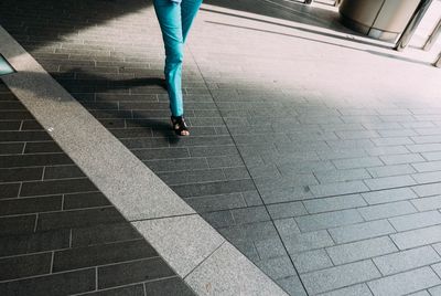 Low section of woman walking on zebra crossing