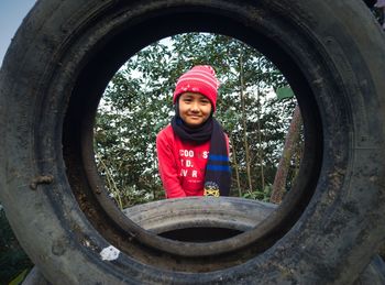 Portrait of smiling girl seen through tire