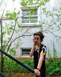 Portrait of woman standing against building