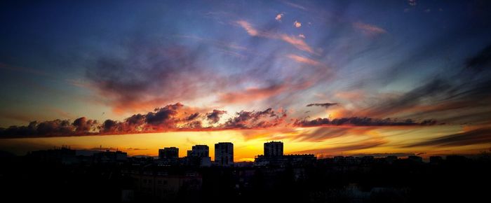 Silhouette buildings against sky during sunset