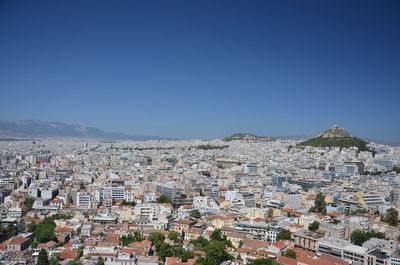 Aerial view of cityscape against clear blue sky