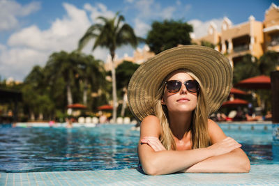 Portrait of young woman wearing sunglasses in swimming pool