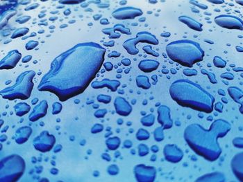 Full frame shot of raindrops on blue water