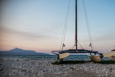 Catamaran parked on the sea shore with mountain view in foreground