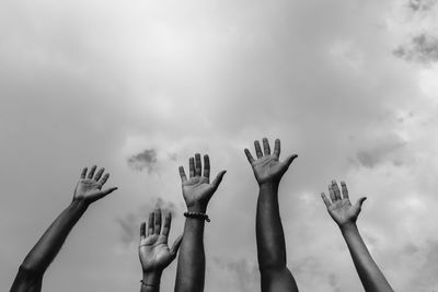 From below of crop anonymous african american social justice warriors raising arms white fighting for social rights during manifestation