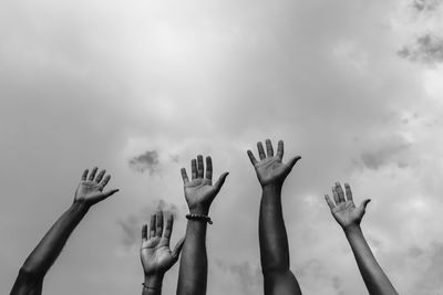 From below of crop anonymous african american social justice warriors raising arms white fighting for social rights during manifestation