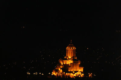 Illuminated building against clear sky at night