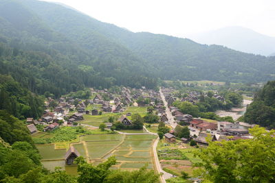 High angle view of houses and trees against mountains
