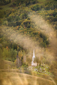 High angle view of church with trees against mountains