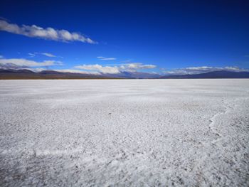 Scenic view of desert against blue sky