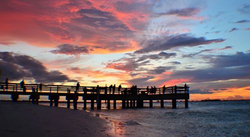 Pier over sea against cloudy sky