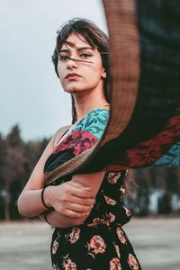 Young woman looking away while standing outdoors