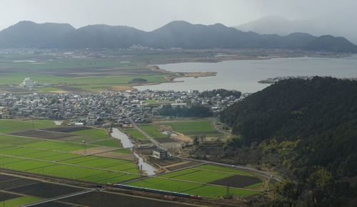 An old diesel locomotive running against the background of nishinoko lake and azuchi-jo castle ruins