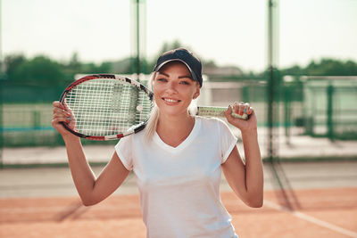 Young beautiful woman in white t-shirt play tennis on court. healthy sport lifestyle