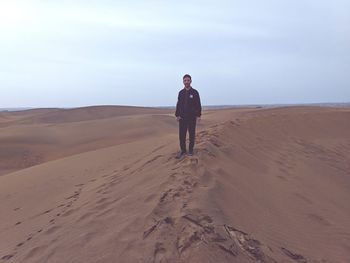 Full length portrait of man standing at desert