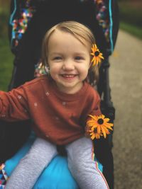 Portrait of cute girl playing with wild flowers