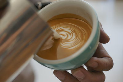 Close-up of hand holding coffee cup