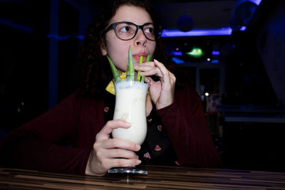 Close-up of woman drinking drink in nightclub