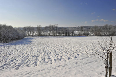 Scenic view of snow covered field against sky