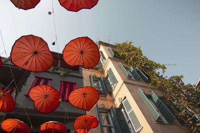 Low angle view of lanterns hanging by building against sky
