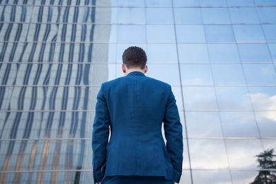 Rear view of businessman standing against modern building