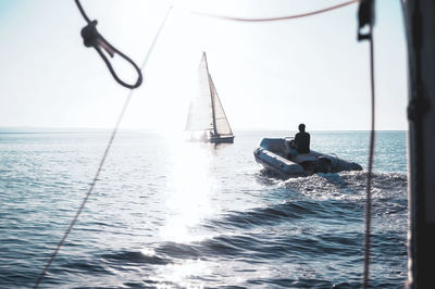 Man sailing on sea against clear sky