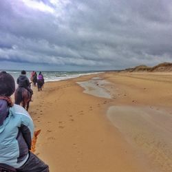 Scenic view of beach against cloudy sky