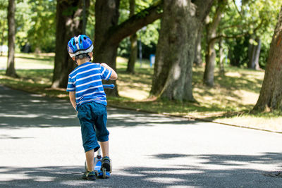 Full length of boy with umbrella on road