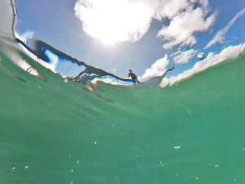 People swimming in sea against sky