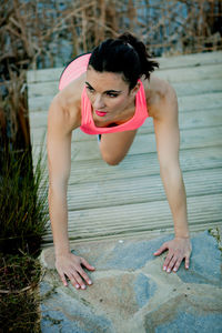 Woman exercising on pier by lake