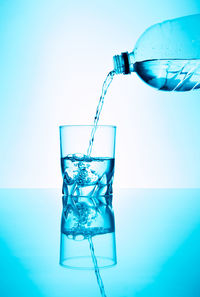 Close-up of drink glass against blue background