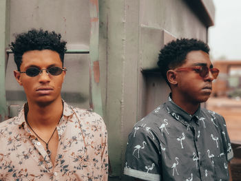 Portrait of young man wearing sunglasses standing outdoors