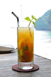 Close-up of cocktail against calm lake