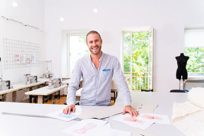 Portrait of fashion designer standing at boutique