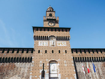 Low angle view of clock tower against blue sky