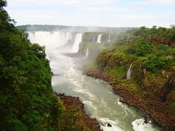 Scenic view of waterfall against sky