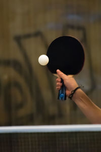 Cropped hand playing table tennis in court